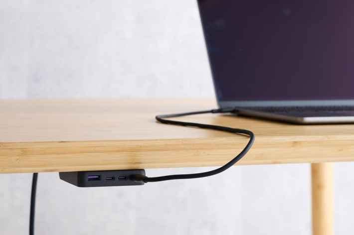 デスクの天板下に設置された黒いNovaPort SLIM QUAD充電器